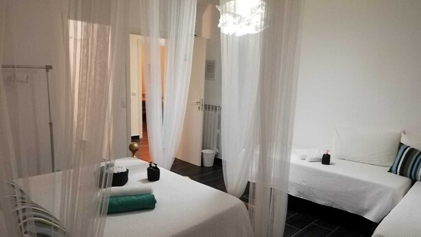 A hotel room with two beds, a bathroom, and a shower area. - Bed and breakfast Style (Rome)