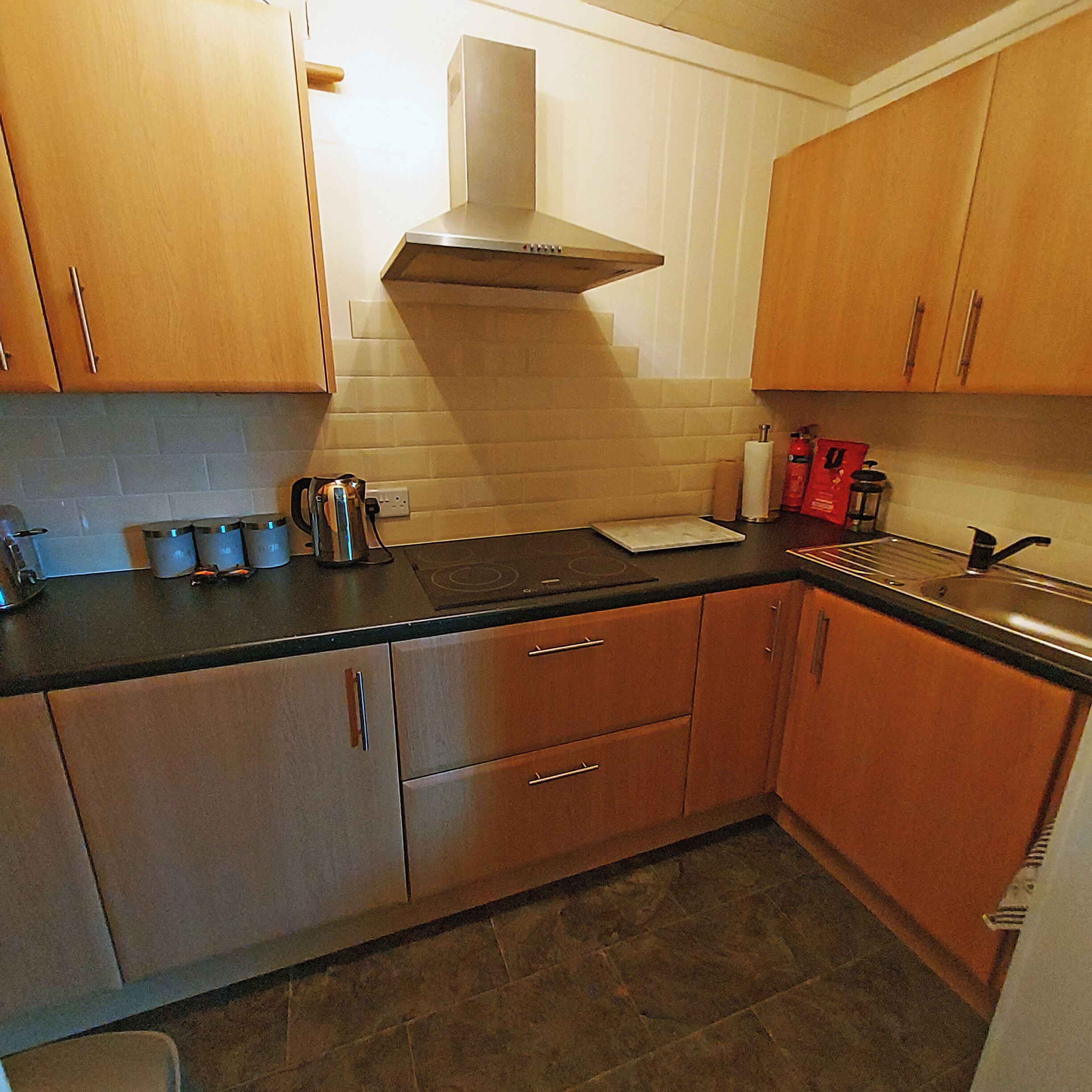 A kitchen with wooden cabinets, a stove, and a sink.