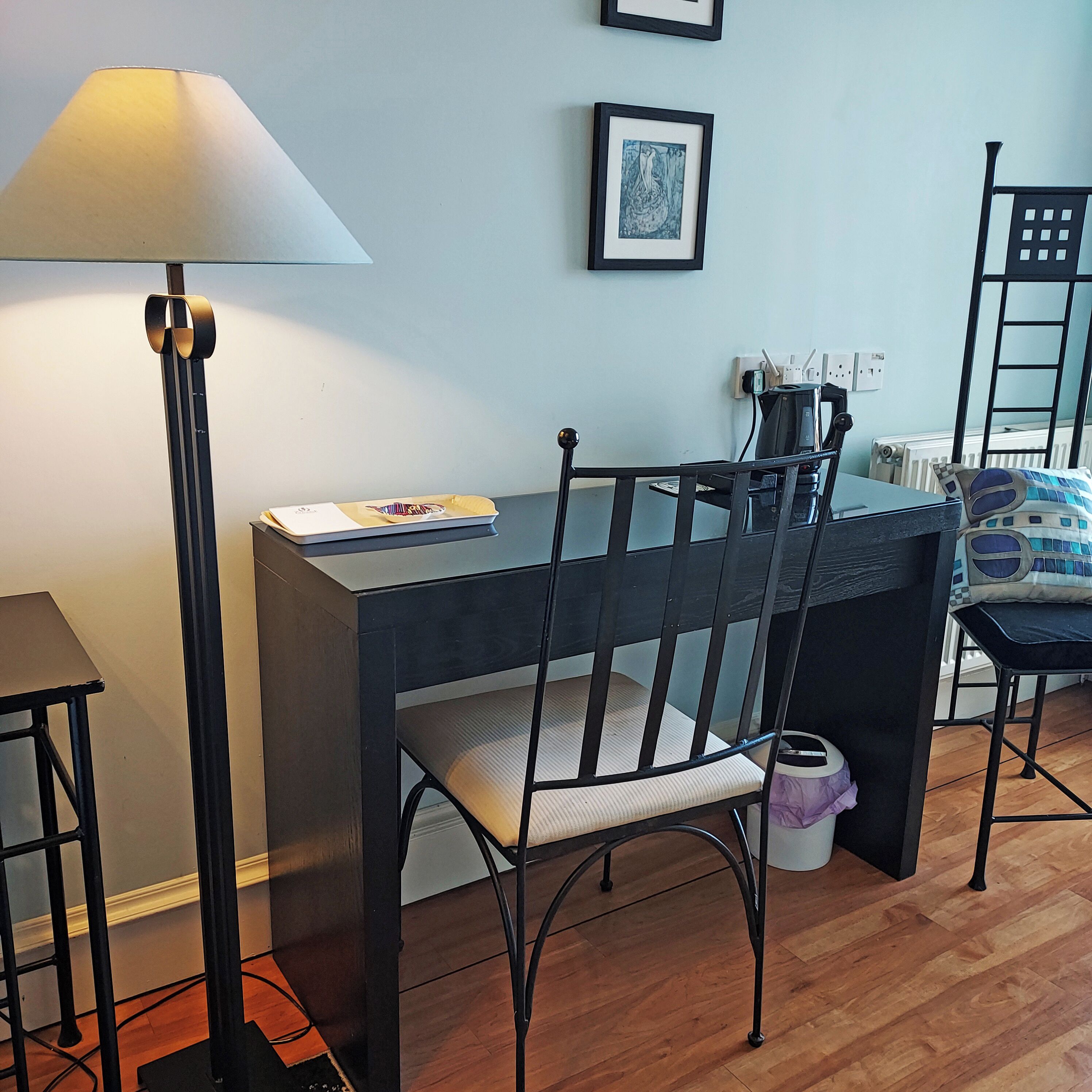 Une pièce comprenant un bureau, une chaise, une lampe et un radiateur.