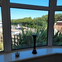 Vista desde una ventana con un florero en el alféizar.