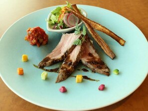 A plate with sliced meat, vegetables, and a small bowl of sauce. - Hotel Kaze no Umi (Shimonoseki)