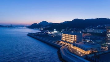 A waterfront hotel with a modern design, featuring a prominent building with multiple floors and a large balcony area.