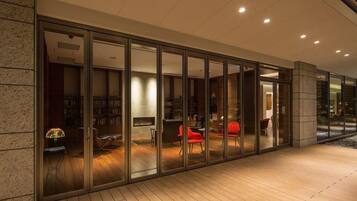 A modern interior with a glass wall, wooden flooring, and a fireplace.