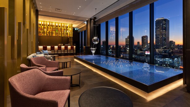 A modern lounge area with a pool table, seating, and a city view. - Osaka Excel Hotel Tokyu (Osaka)