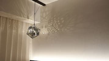 A bedroom with a geometric patterned light fixture casting intricate shadows on the wall.