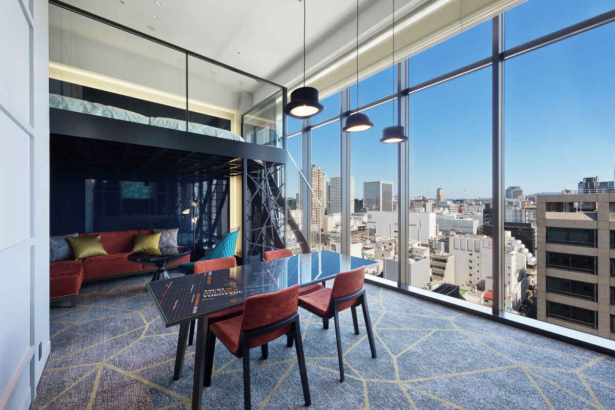 Une salle de conférence moderne avec une table en verre, des chaises rouges et une vue sur la ville.