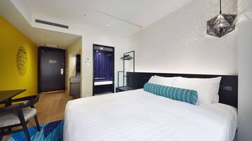Quarto de hotel moderno com uma cama grande, uma escrivaninha e uma cadeira.