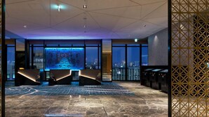 A modern lobby with a large digital display, a reception desk, and a view of the cityscape through large windows. - Osaka Excel Hotel Tokyu (Osaka)