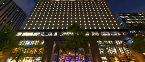 A modern hotel with a central entrance, multiple floors, and a prominent glass facade.