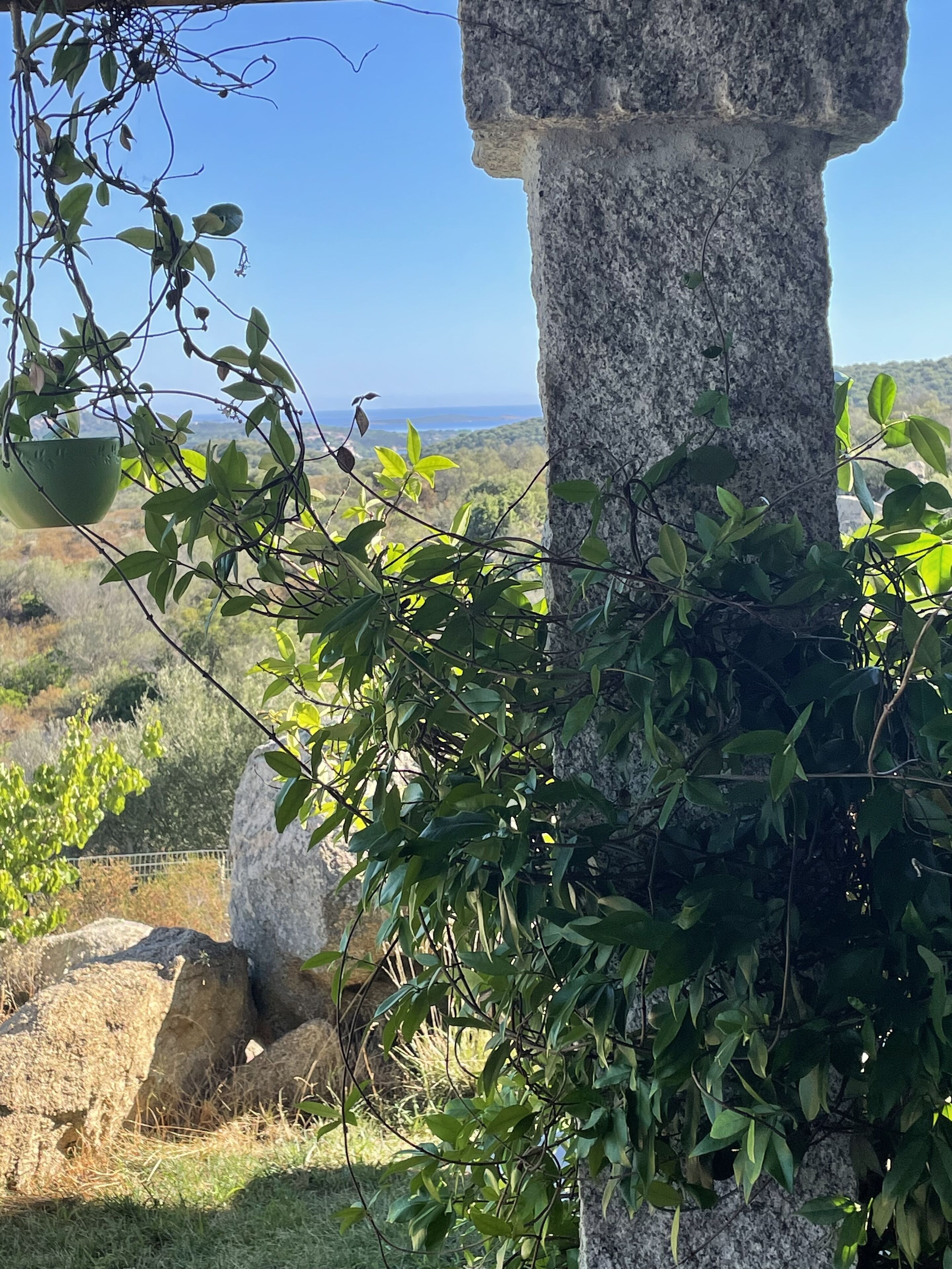Un monumento de piedra rodeado de vegetación, con vistas al paisaje y al horizonte distante.