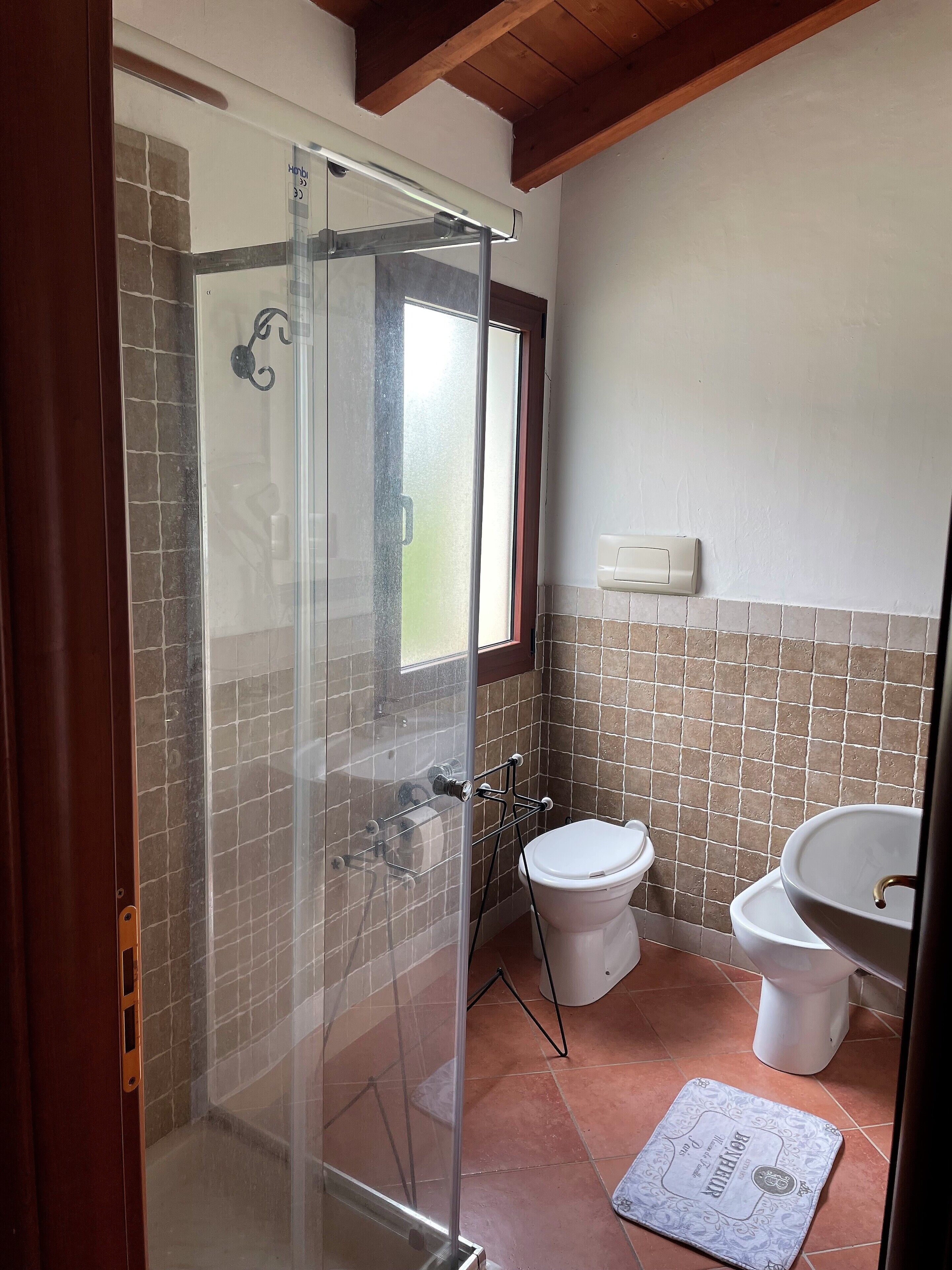 Ein Badezimmer mit Duschkabine, Toilette und Waschbecken.