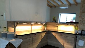 Eine moderne Küche mit Holzausstattung, einem eingebauten Herd und einem Fenster für natürliches Licht.