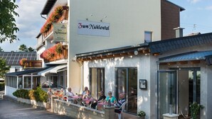 Ein Restaurant namens Zum Nühltal mit Außenbestuhlung und einer modernen Fassade.