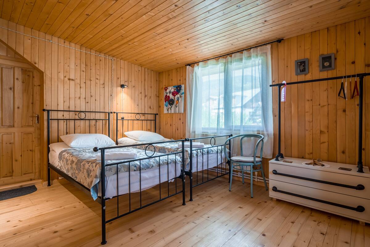 Habitació amb panells de fusta, un llit, una cadira i un armari.