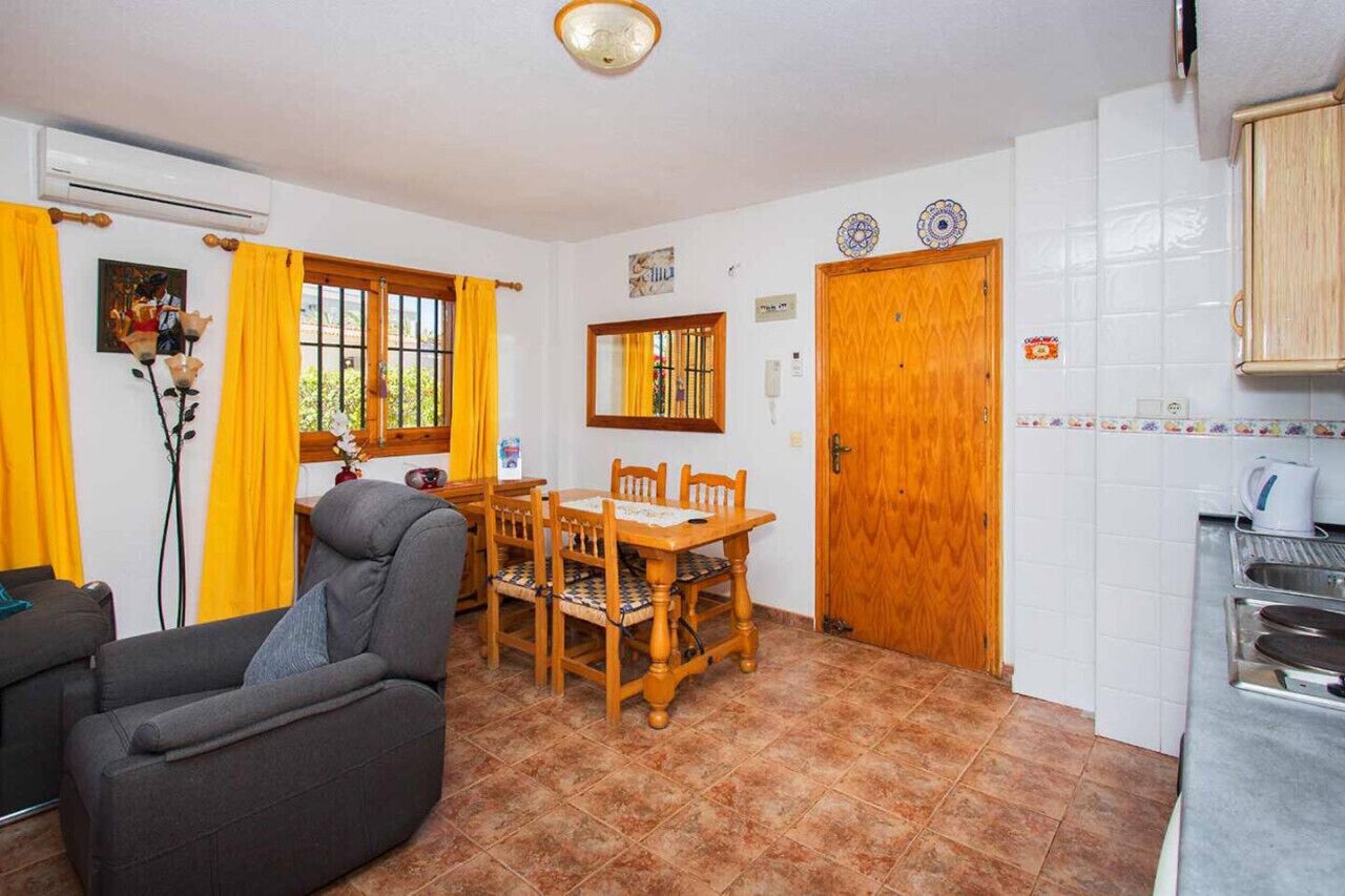 Un espai vital compacte amb zona de menjador, sofà i cuina.