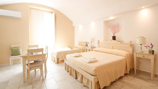 Une chambre d’hôtel avec deux lits, un bureau, une chaise et une table de chevet avec une lampe.