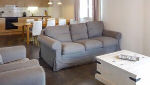 Un salon moderne avec un canapé gris, un fauteuil assorti et une table basse en bois.