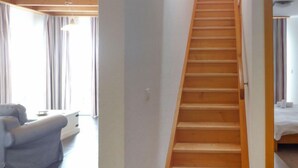 Un escalier menant à une chambre à coucher avec un lit et une fenêtre.