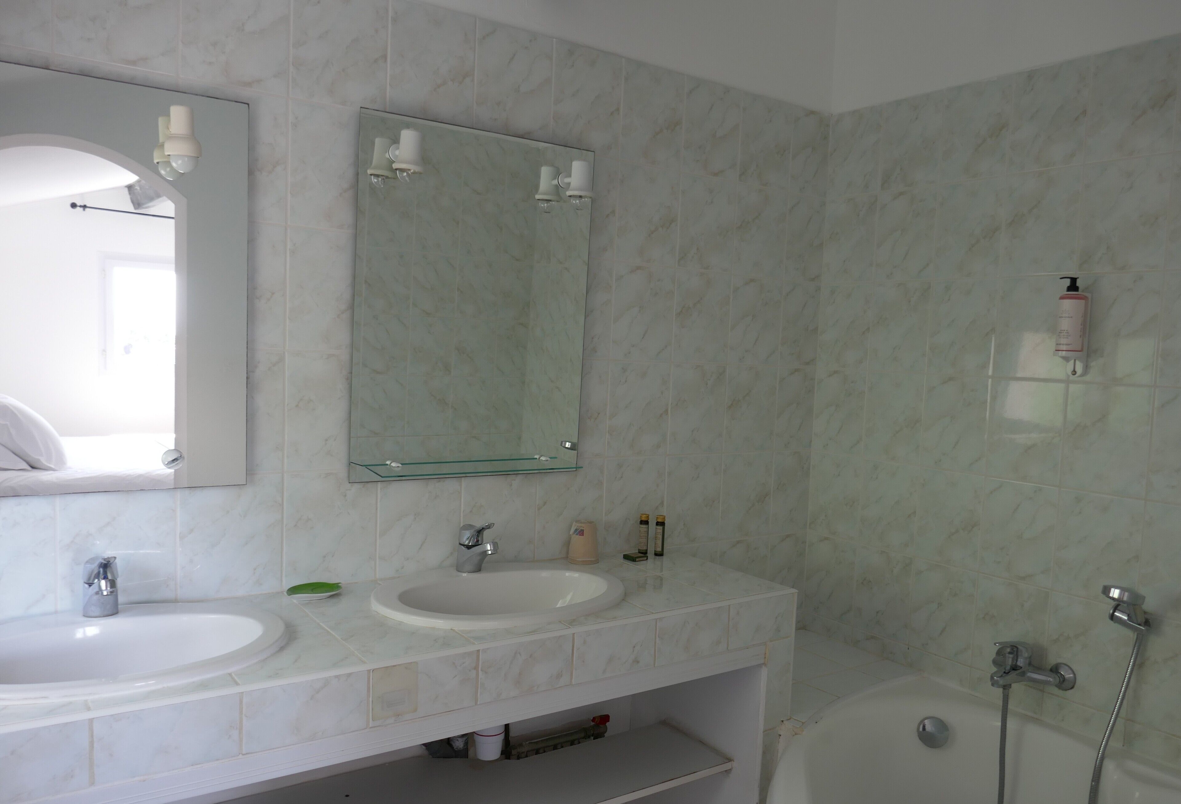 Baño con dos lavamanos, espejo y ducha.