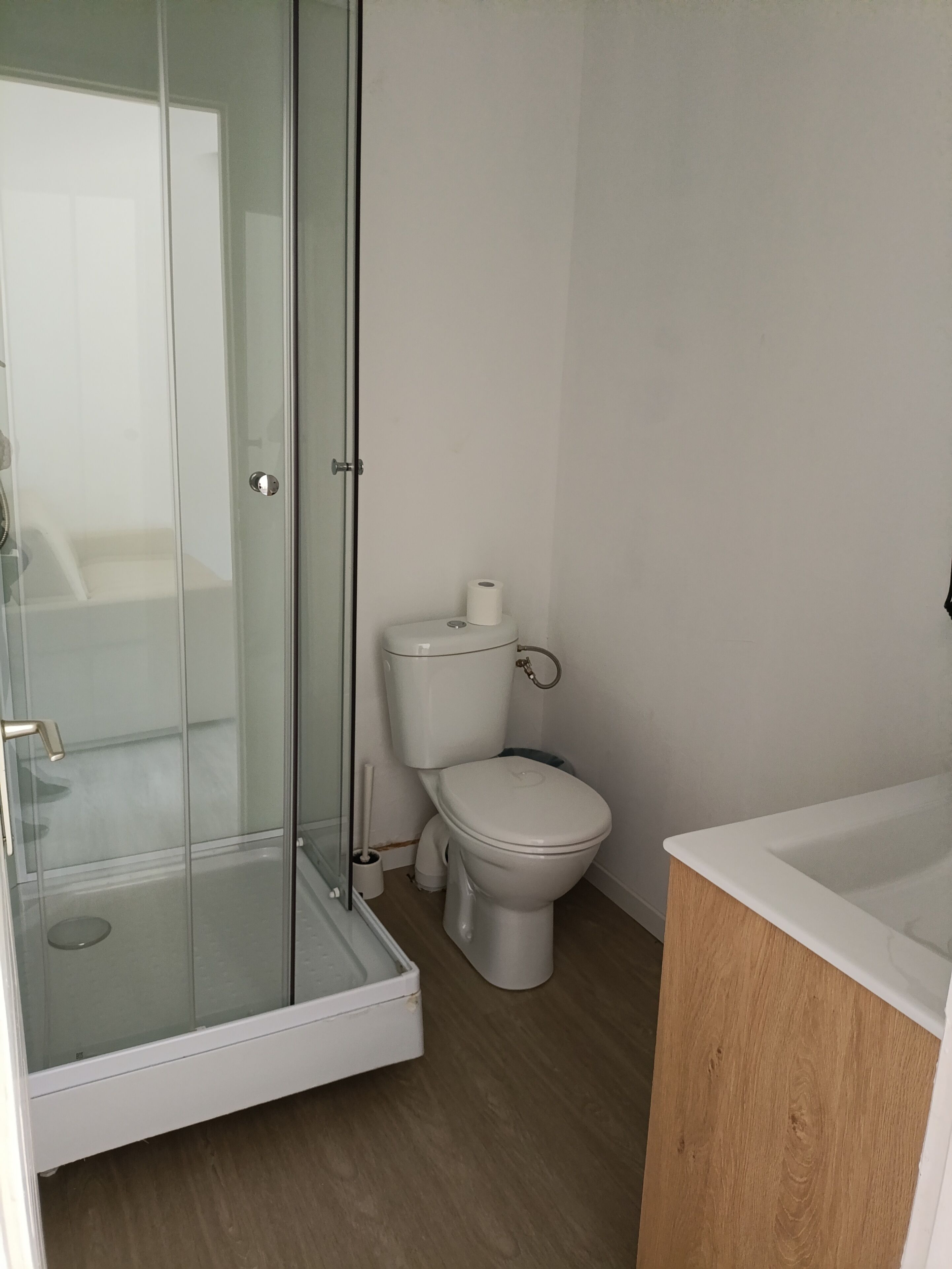 Un baño moderno con cabina de ducha de vidrio, inodoro y bañera.
