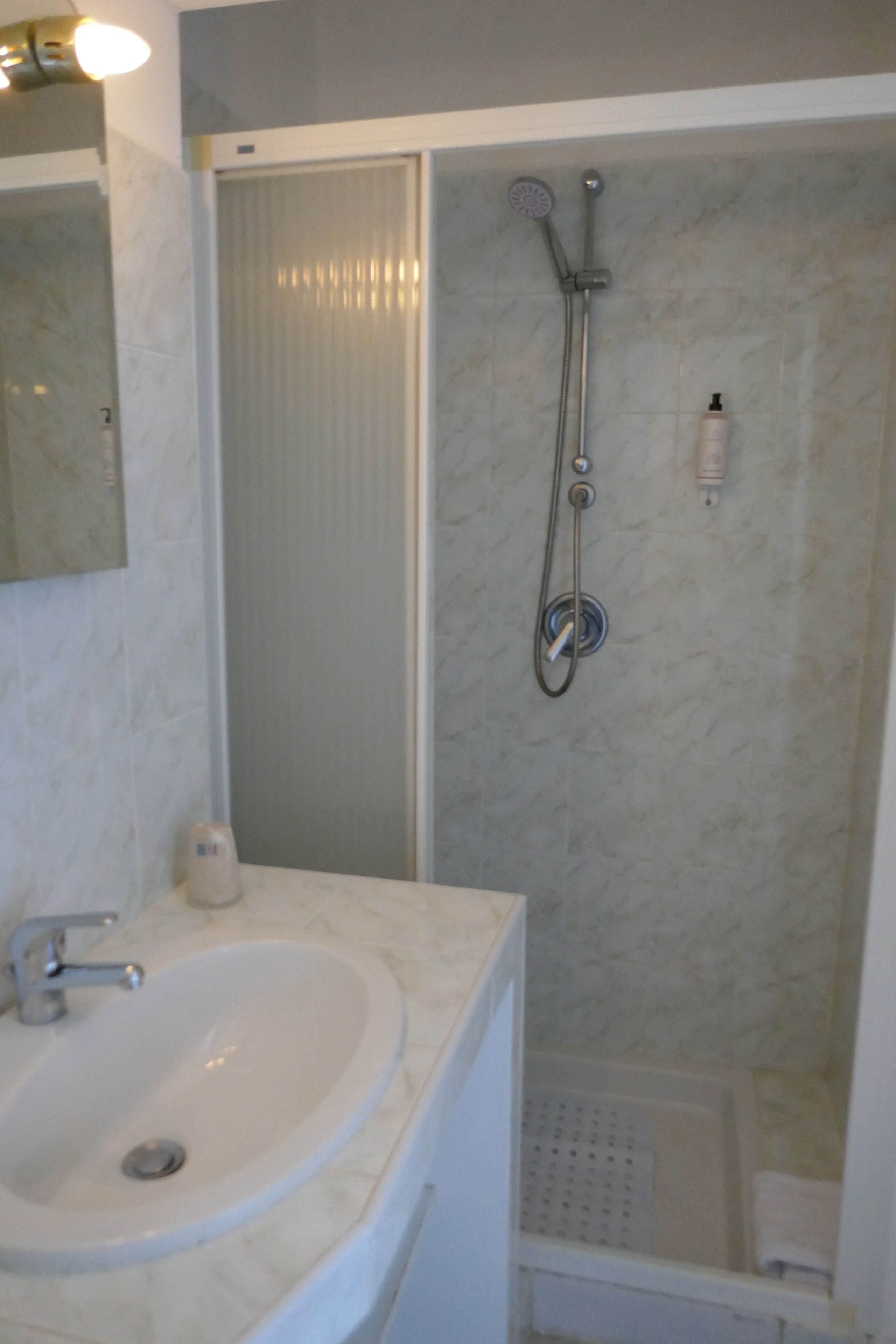 A bathroom with a sink, a shower, and a toilet.