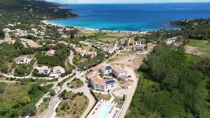 An aerial view of a coastal residential area with houses, a swimming pool, and a beach. - Résidence les Pavillons du Golfe (Conca)