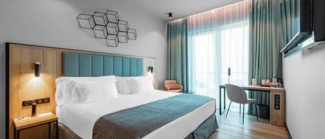 Een moderne hotelkamer met een groot bed, een bureau en een stoel.