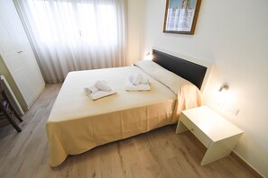 Habitación cuádruple | Edredones de plumas, minibar, caja fuerte y escritorio