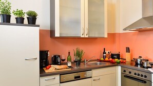 A kitchen with a dishwasher, oven, and a variety of kitchen items on the counter. - Ferienwohnung Panoramablick (Kastellaun)
