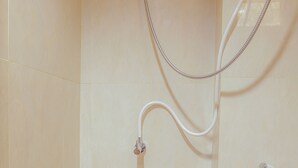A shower with a handheld showerhead and a wall-mounted faucet. - OYO 630 Green Lake View Cimanggis (Depok)