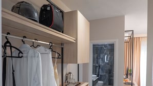 A modern hotel room with a walk-in closet, a shower area, and a view of the outside. - Villa Green Garden (Sarandë)