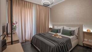 A modern hotel room with a large bed, a desk, and a chair. - Villa Green Garden (Sarandë)