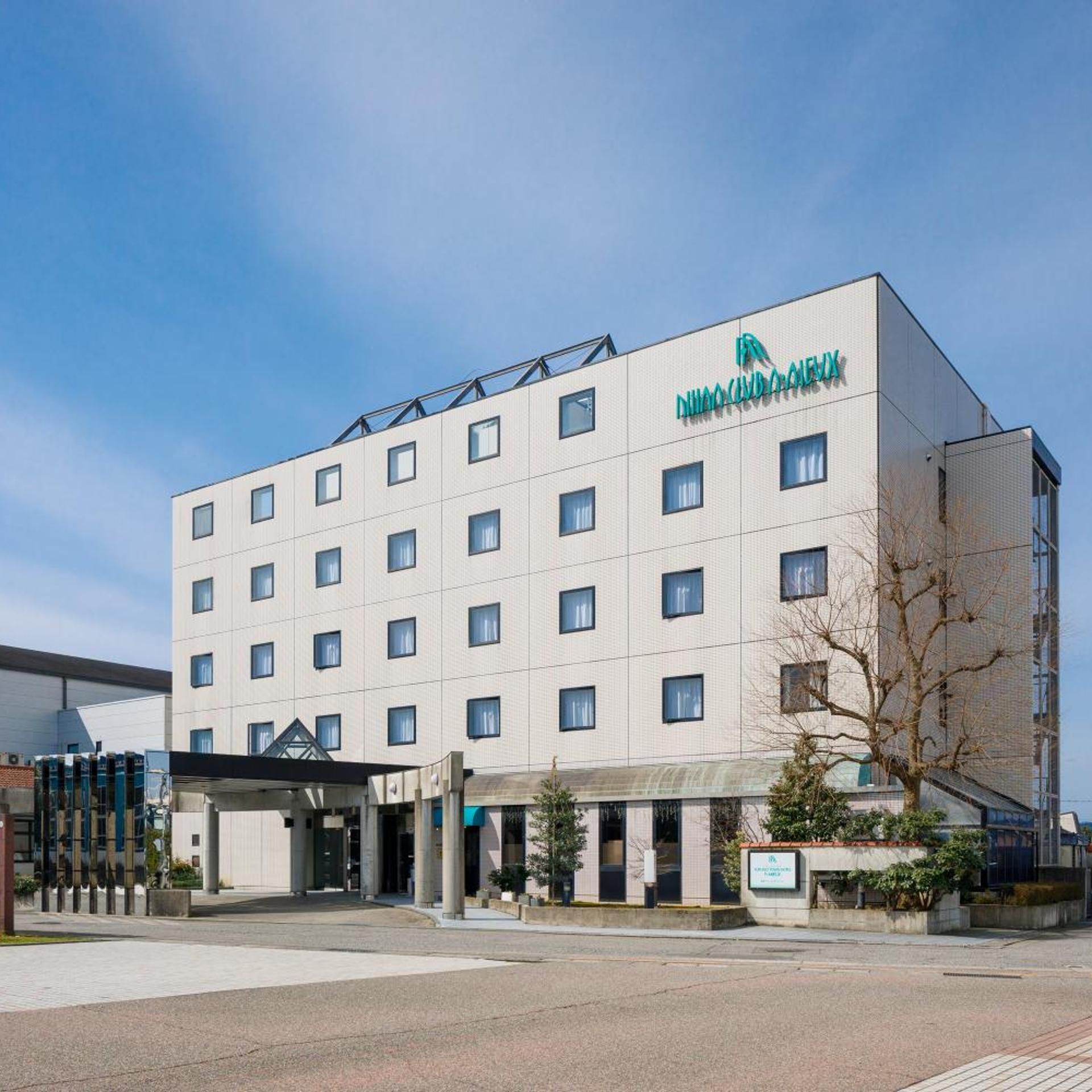 A multi-story hotel building with a modern design, featuring a prominent logo on the facade.