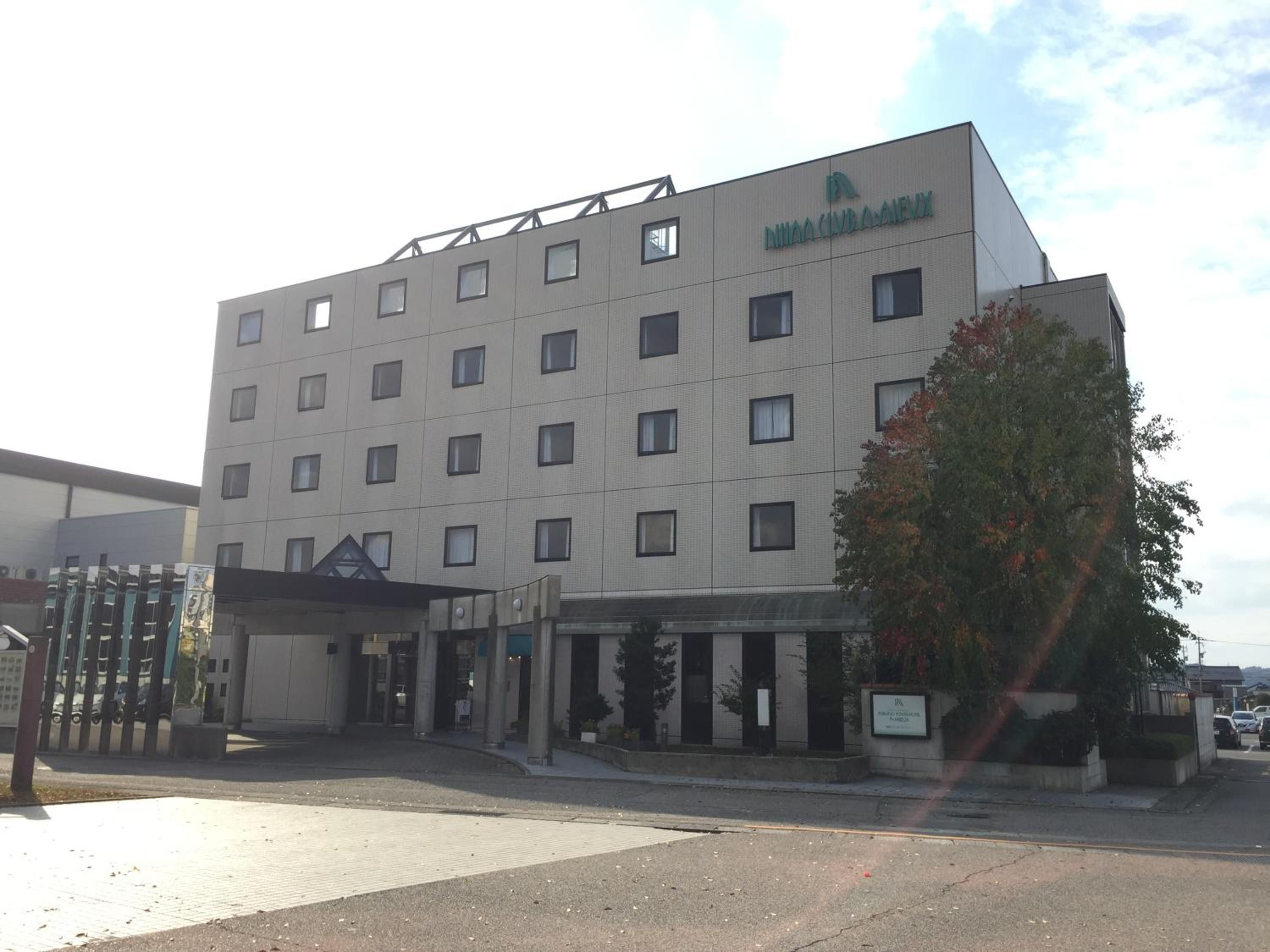 A multi-story hotel building with a flat facade, numerous windows, and a sign indicating it is a hotel.