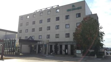 A multi-story hotel building with a flat facade, numerous windows, and a sign indicating it is a hotel.