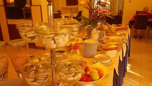 A buffet setup with various food items and condiments. - Hotel Abel (Cesenatico)