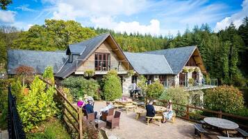 Situated in a serene forest, this lodge offers a traditional cabin-style retreat with outdoor seating areas and manicured gardens.