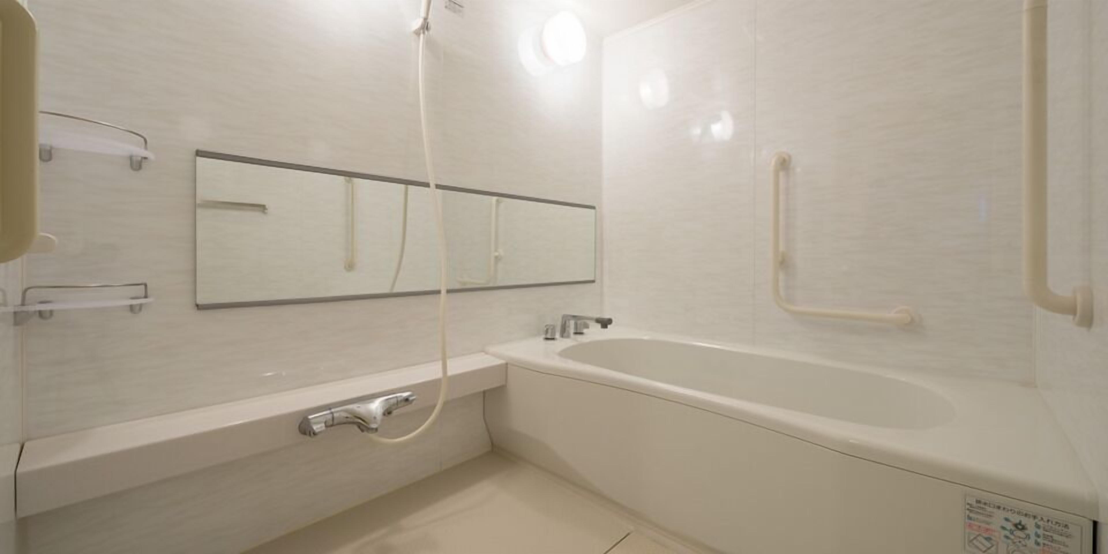 A modern bathroom with a bathtub, a shower, and a toilet.