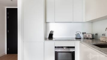 Departamento Confort, 1 cama matrimonial, vista a la ciudad | Cocina privada | Refrigerador, microondas, horno y parrilla de estufa