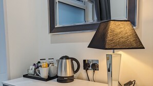 A modern kitchen with a white countertop, a kettle, a coffee maker, and a lamp. - Hotel 33 (Blackpool)