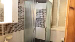 Ein Badezimmer mit Duschkabine, Waschbecken und Toilette.