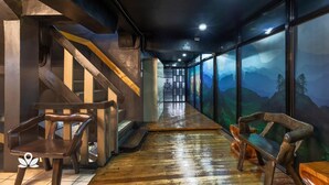 A corridor with wooden benches, a staircase, and a mural of a mountainous landscape. - 3BU Hostel Baguio (Baguio)