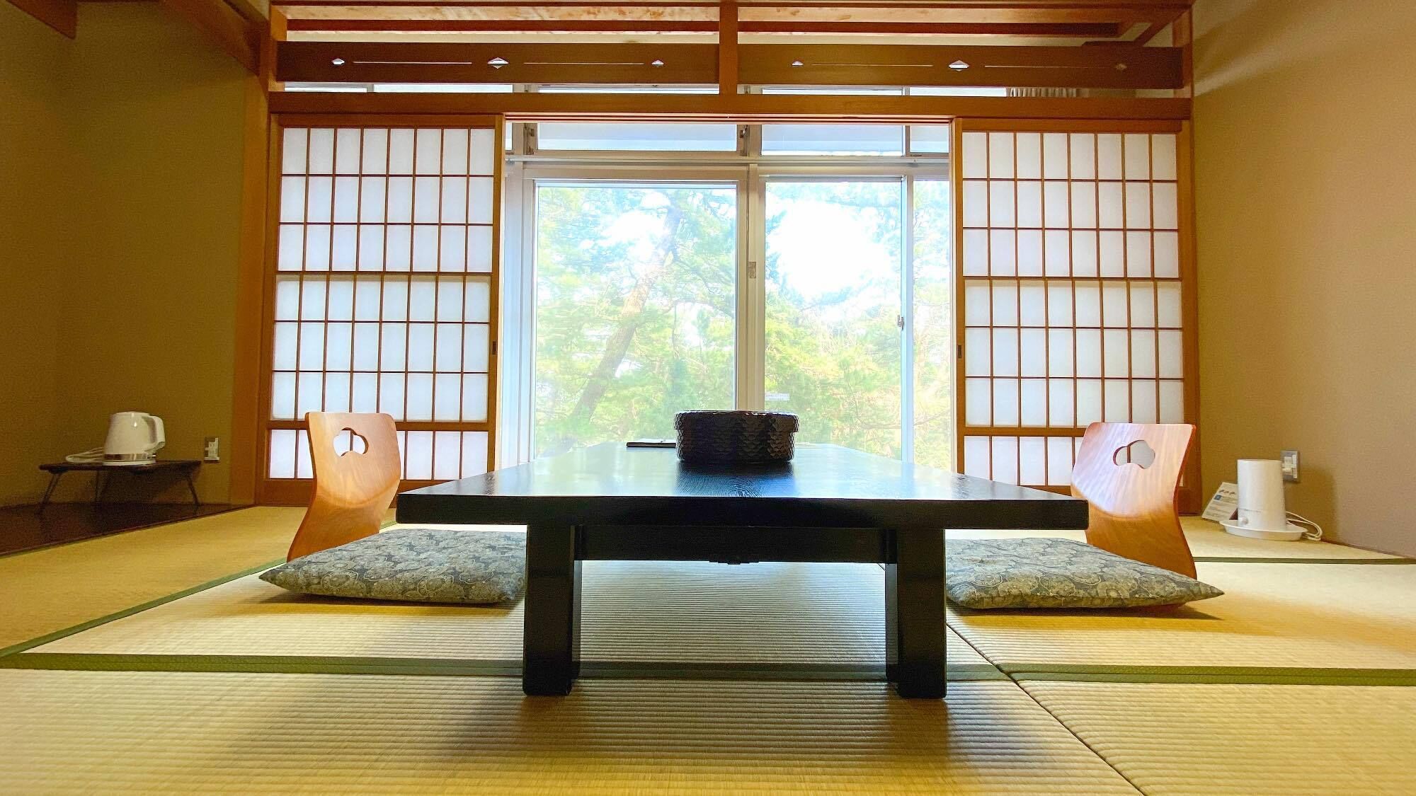 A traditional Japanese room with tatami flooring, a low table, and shoji screens.