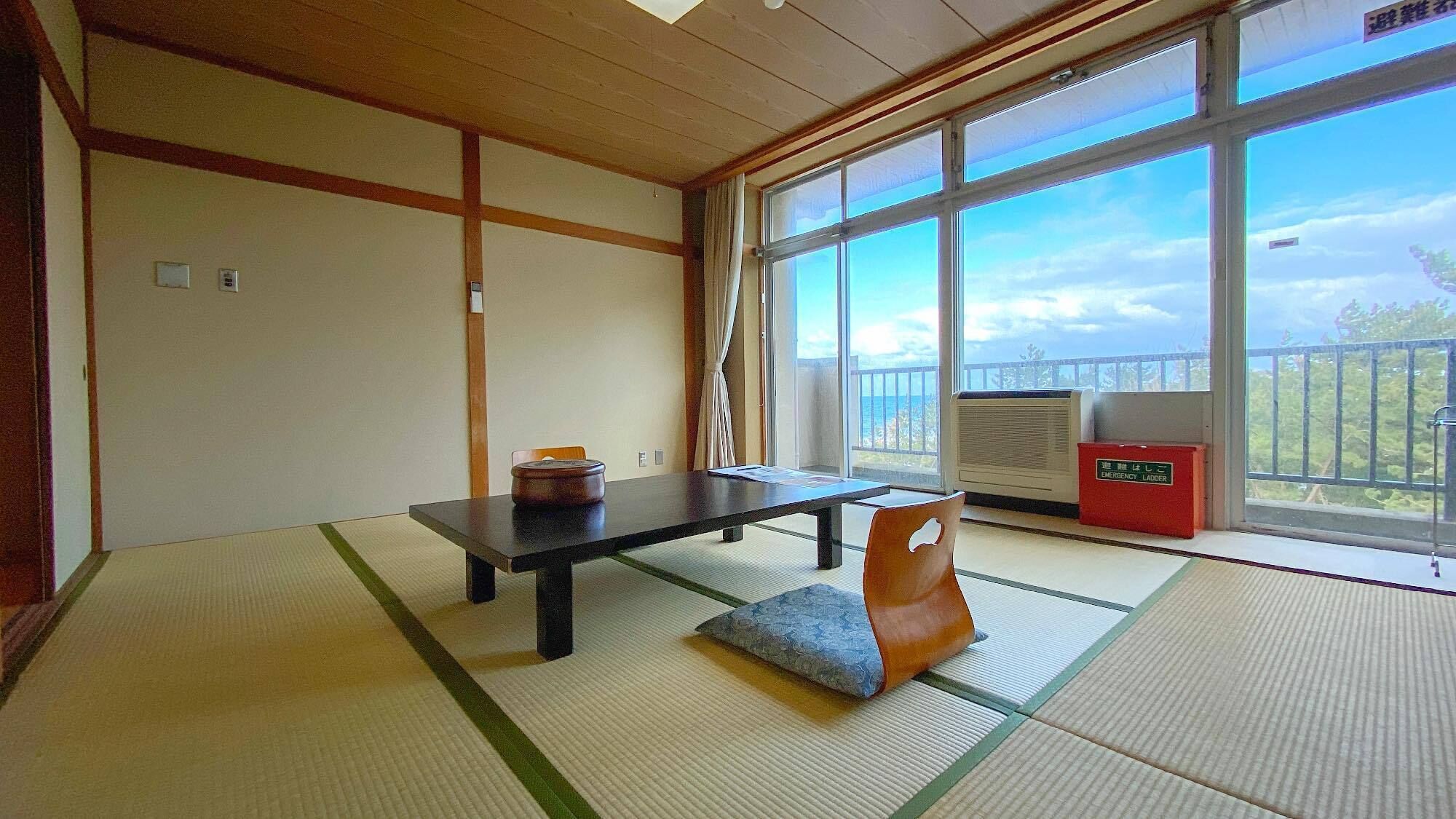 A tatami mat room with a low table, a cushion, and a view of the outdoors.