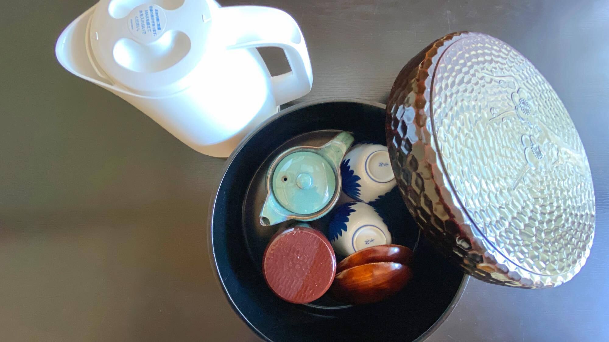 A tea set with a teapot, cups, and a saucer on a table.