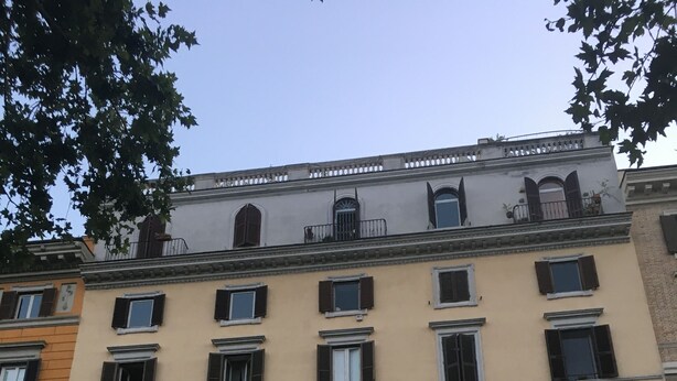 A multi-story building with a symmetrical facade, featuring evenly spaced windows and a central entrance with an arched doorway. - All You Need Is Rome Guesthouse (Rome)
