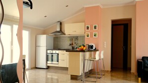 A modern kitchen with a central island, stainless steel appliances, and a tiled floor. - Galini beach studios (Corfu)