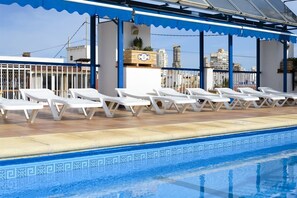 Een buitenzwembad en ligstoelen