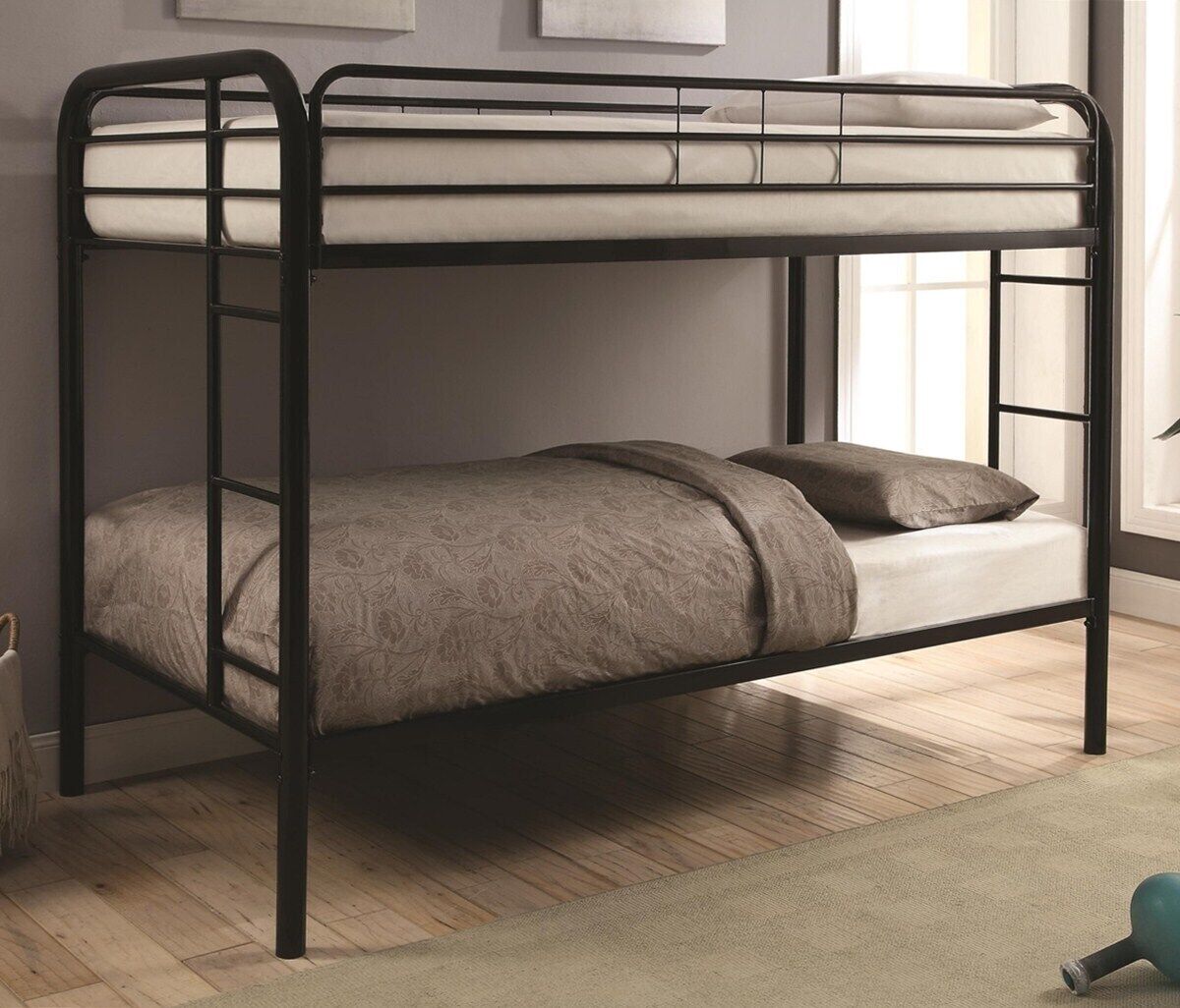 Un letto a castello con materasso e cuscini, un pavimento in legno e una finestra con tende.
