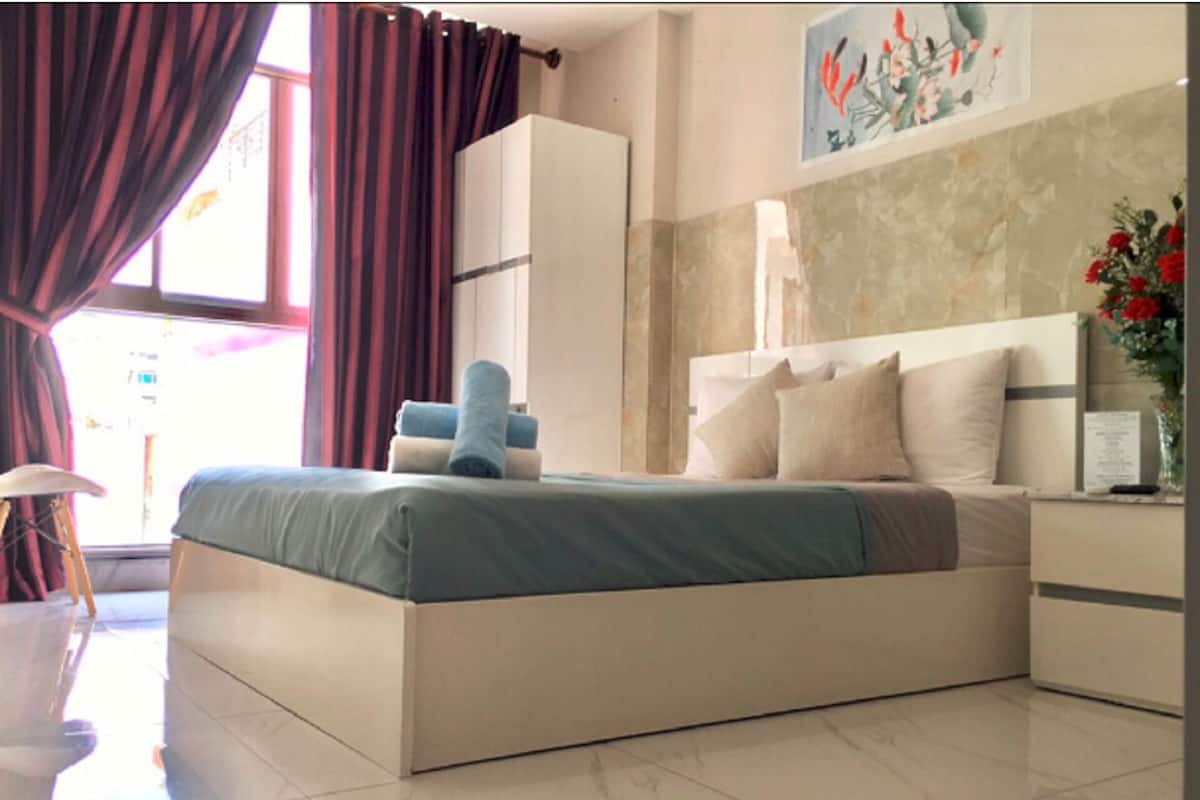 Une chambre moderne avec un grand lit, une armoire, un bureau et une chaise.